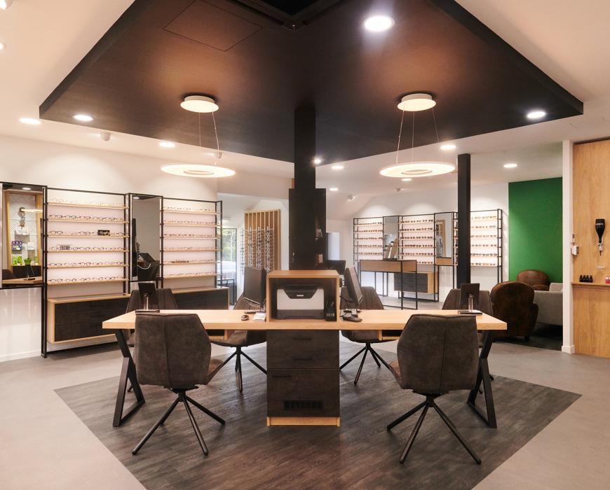 Repenser son agencement en diminuant son exposition tout en la mettant plus en valeur Et profiter de son extension pour accueillir au mieux ses clients Des mobiliers sur mesure bois/métal avec éclairage intégré Une salle d’examen de vue Un atelier ouvert sur l’espace de vente Un ilot de table de vente facilitant la circulation périphérique