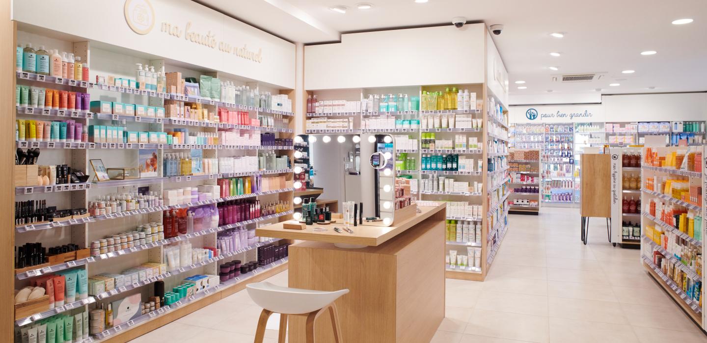 Aménagement intérieur de la pharmacie Monsieur Oliveira à Bouaye réalisé par JBCC, avec espaces de vente modernes, accueil, plots d’animation et cabines de confidentialité.