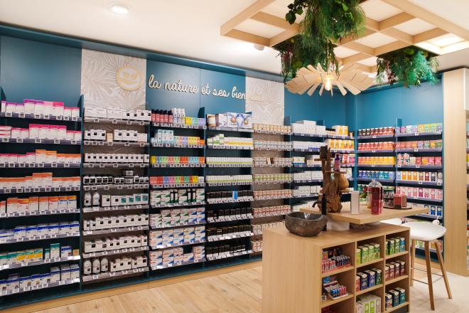 Aménagement intérieur de la pharmacie Monsieur Oliveira à Bouaye réalisé par JBCC, avec espaces de vente modernes, accueil, plots d’animation et cabines de confidentialité.