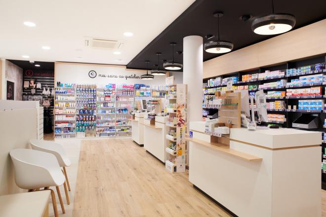 Aménagement intérieur de la pharmacie Monsieur Oliveira à Bouaye réalisé par JBCC, avec espaces de vente modernes, accueil, plots d’animation et cabines de confidentialité.