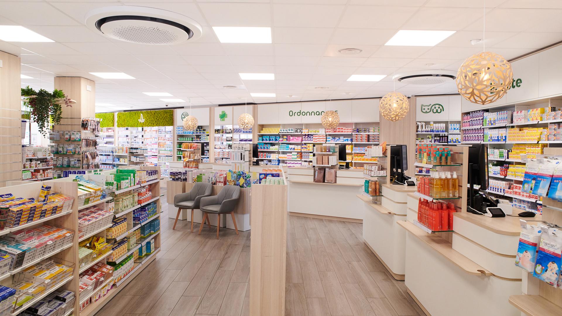 Vue d'ensemble de l'agencement d'une pharmacie moderne avec comptoirs sur-mesure en bois et sol effet parquet