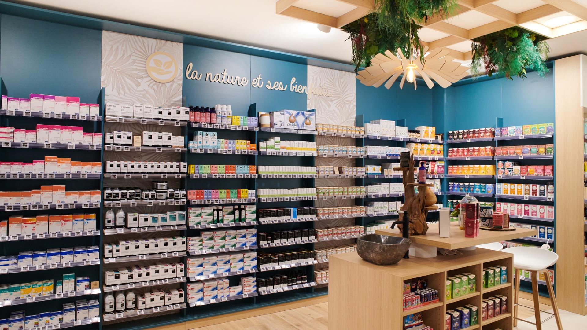 Aménagement intérieur de la pharmacie Monsieur Oliveira à Bouaye réalisé par JBCC, avec espaces de vente modernes, accueil, plots d’animation et cabines de confidentialité.