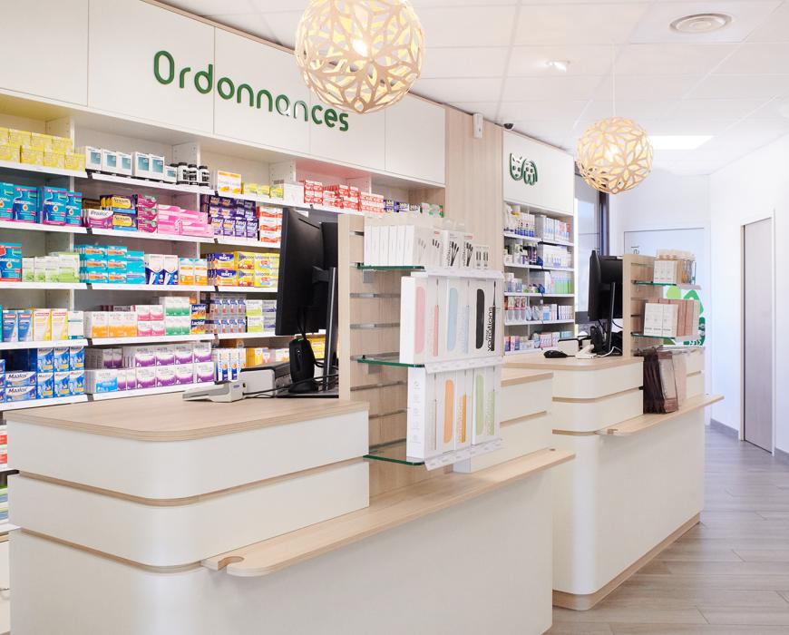 Comptoirs d'accueil de pharmacie en bois et blanc avec suspensions lumineuses design.