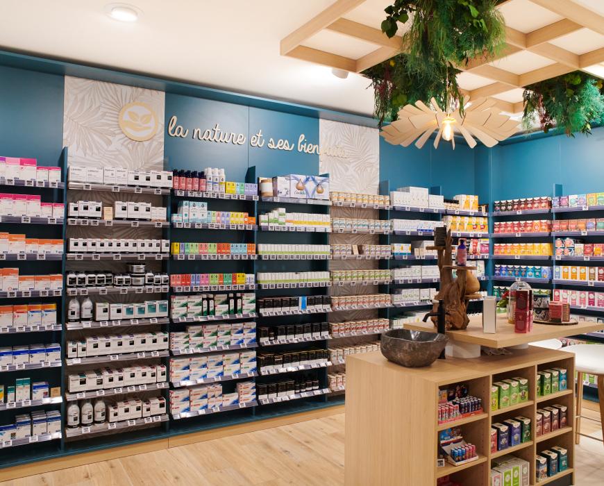 Aménagement intérieur de la pharmacie Monsieur Oliveira à Bouaye réalisé par JBCC, avec espaces de vente modernes, accueil, plots d’animation et cabines de confidentialité.