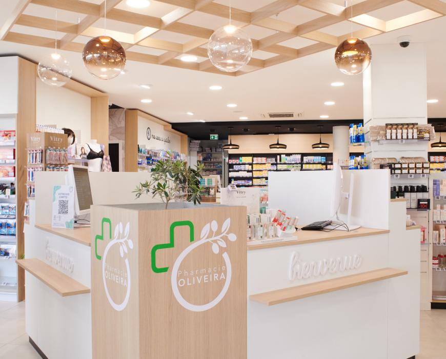 Aménagement intérieur de la pharmacie Monsieur Oliveira à Bouaye réalisé par JBCC, avec espaces de vente modernes, accueil, plots d’animation et cabines de confidentialité.