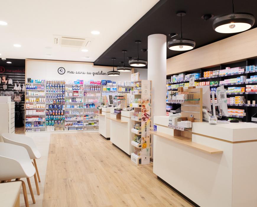 Aménagement intérieur de la pharmacie Monsieur Oliveira à Bouaye réalisé par JBCC, avec espaces de vente modernes, accueil, plots d’animation et cabines de confidentialité.