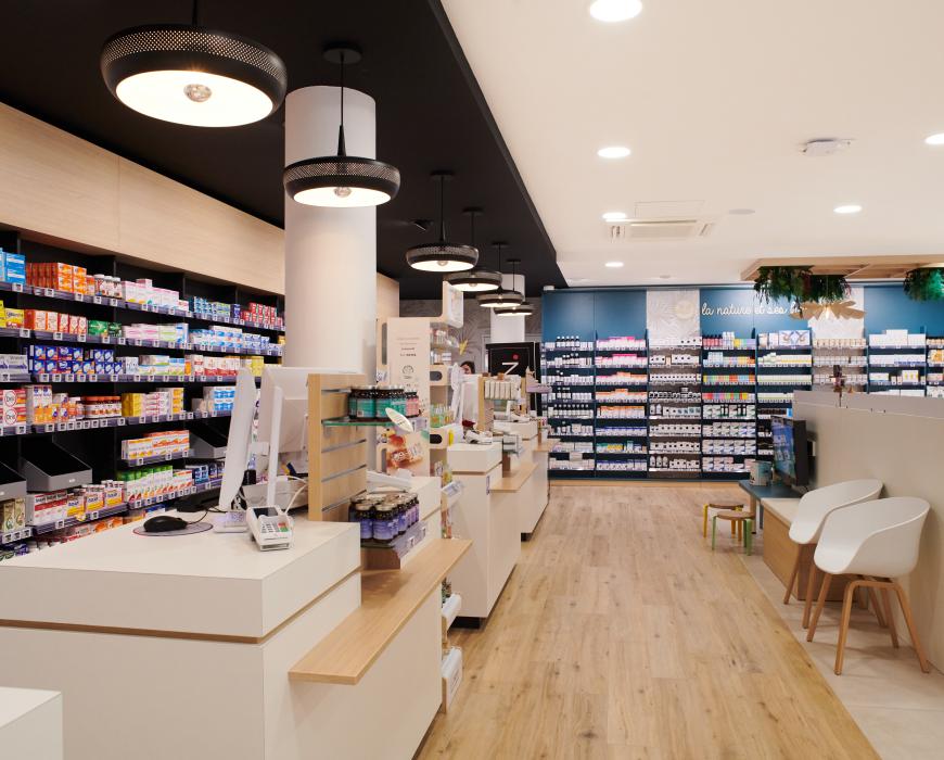 Aménagement intérieur de la pharmacie Monsieur Oliveira à Bouaye réalisé par JBCC, avec espaces de vente modernes, accueil, plots d’animation et cabines de confidentialité.