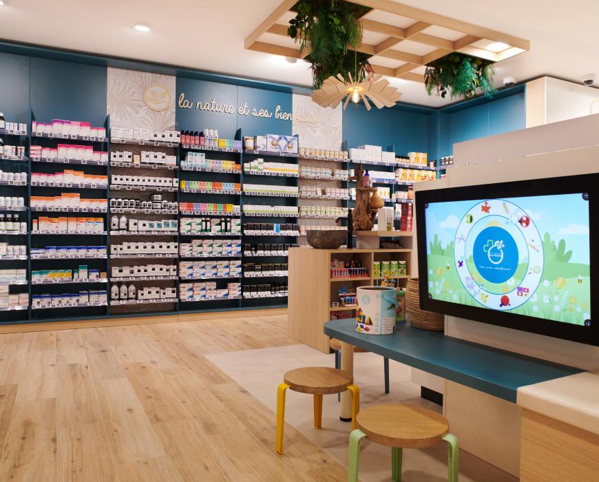 Aménagement intérieur de la pharmacie Monsieur Oliveira à Bouaye réalisé par JBCC, avec espaces de vente modernes, accueil, plots d’animation et cabines de confidentialité.