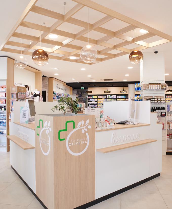 Aménagement intérieur de la pharmacie Monsieur Oliveira à Bouaye réalisé par JBCC, avec espaces de vente modernes, accueil, plots d’animation et cabines de confidentialité.